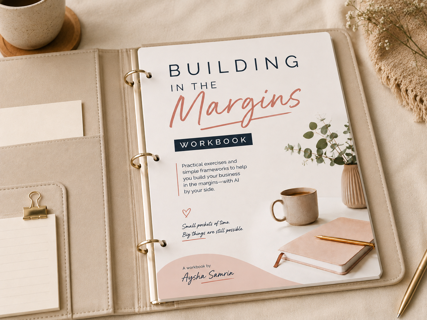 The Building in the Margins workbook open in a binder on a linen desk